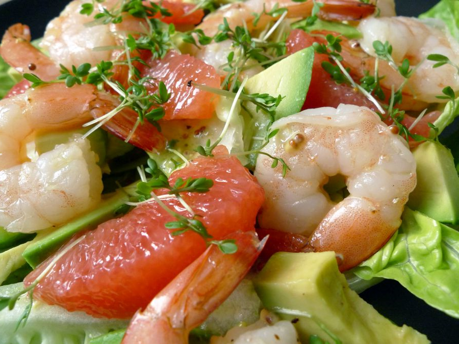 Een elegant voorgerechtje met romige avocadomousse, sappige garnalen en kleurrijke paprika