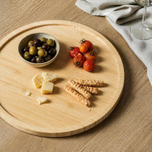 Bamboe draaiplateau met tapas van bovenaf op een eiken eettafel