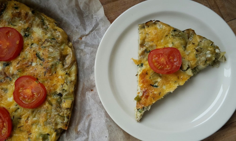 Een luchtige italiaanse omelet met courgette, artisjokharten en verse kruiden