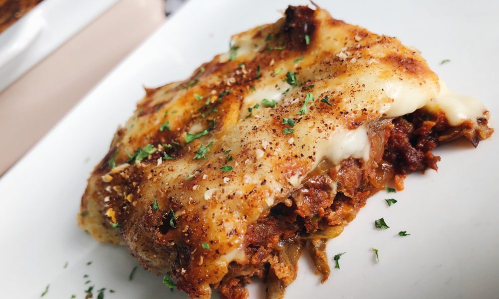 Een klassiek Grieks ovenschotel met aubergine, gekruid gehakt en romige bechamelsaus