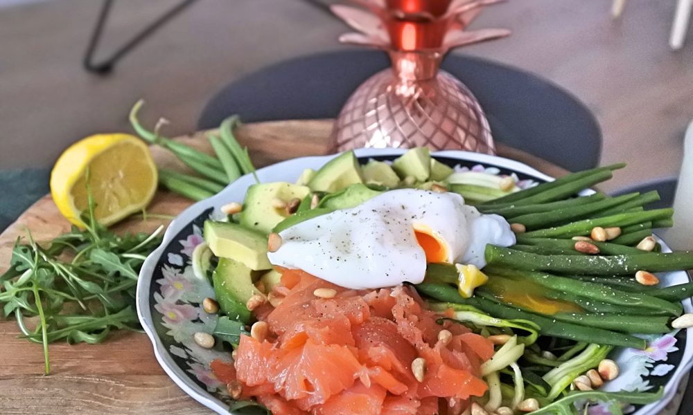 Een frisse en voedzame bowl met courgetteslierten, gerookte zalm en een gepocheerd eitje